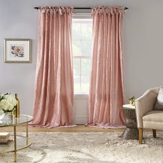 a living room filled with furniture and pink curtains