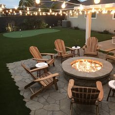 a fire pit surrounded by chairs and lights