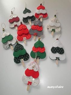 a bunch of christmas tree ornaments hanging from clothes pins on a white table with polka dots