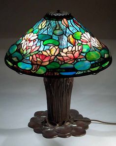 a lamp that is sitting on top of a table next to a light bulb with flowers on it