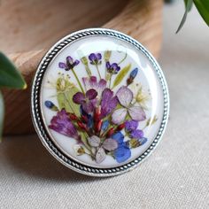 a flower brooch sitting on top of a table next to a potted plant