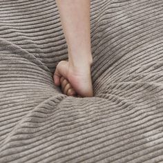 a person's foot sticking out from under a blanket