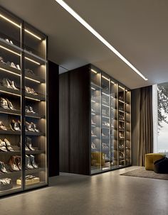 a walk in closet filled with lots of shoes next to a large glass doored window