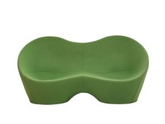 a green curved couch sitting on top of a white floor