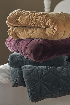 a stack of blankets sitting on top of a bed