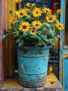 a blue bucket filled with lots of yellow flowers