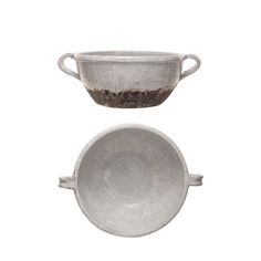 two metal bowls sitting next to each other on top of a white surface with dirt in them