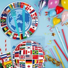 a table topped with plates covered in flags and balloons