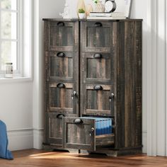 an old wooden cabinet with drawers in the corner next to a blue chair and window