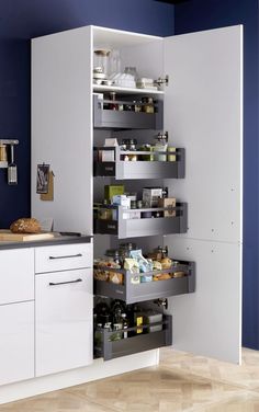 a kitchen with white cabinets and shelves filled with food