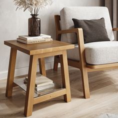 a living room with a chair, table and books on the floor next to a window