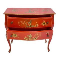 an antique red and gold painted chest with two drawers on each side, decorated with flowers