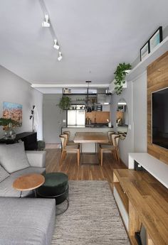 a living room filled with furniture and a flat screen tv on top of a wooden table