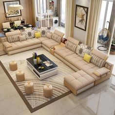 a large living room with beige couches and candles on the coffee table in front of it