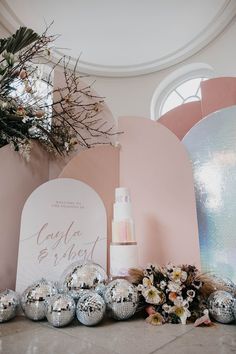 a table topped with lots of shiny silver balls and flowers next to a sign that says glob blvd