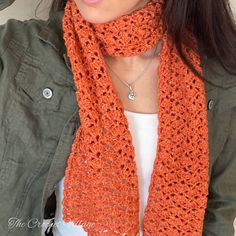 a woman wearing an orange crocheted scarf