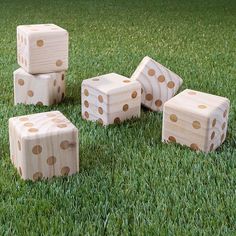 four wooden dices sitting on top of green grass