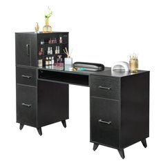 an office desk with two drawers and bottles on the top, next to it is a black cabinet