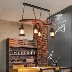 a dining room table and chairs with lights hanging from the ceiling over it, next to a brick wall