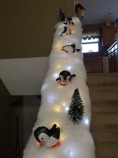 a christmas tree made out of snow with penguins on it