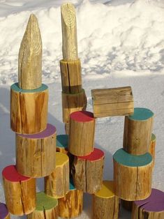 a pile of wooden logs sitting on top of snow covered ground