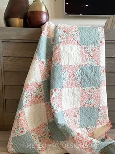 a quilted blanket sitting on top of a wooden dresser