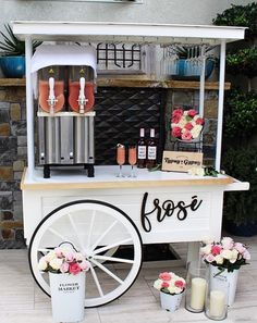 an ice cream cart with flowers on the side and some drinks in front of it