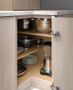 an open cabinet in a kitchen filled with dishes