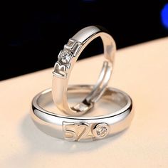 two wedding rings with the word love written on each one and diamond in the middle