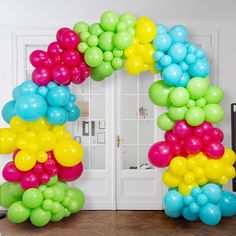 a bunch of balloons that are in the shape of a wreath on a door way