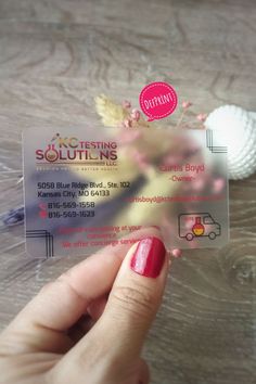 a person holding up a plastic business card