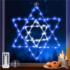 the star of david has been decorated with blue lights and is next to some donuts