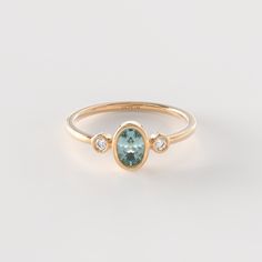 𝟏𝟒𝐤 𝐒𝐨𝐥𝐢𝐝 𝐆𝐨𝐥𝐝 𝐎𝐯𝐚𝐥 𝐓𝐞𝐚𝐥 𝐒𝐚𝐩𝐩𝐡𝐢𝐫𝐞 𝐑𝐢𝐧𝐠 The Diamond Teal Sapphire Bezel Ring is a stunning piece of handmade jewelry crafted in 14k solid gold. Featuring a small oval blue sapphire in a delicate bezel setting, this ring is a beautiful and unique statement of elegance. The addition of diamonds adds a touch of sparkle and sophistication to the design. Perfect as a promise ring or a dainty accessory, this handmade piece is a thoughtful and stylish gift for someone spe Sapphire Ring White Gold, Oval Sapphire Diamond Ring With Bezel Setting, Oval 14k Gold Rings With Bezel Setting, Fine Jewelry Oval Topaz Ring With Bezel Setting, Oval Topaz Ring With Bezel Setting - Fine Jewelry, Oval Topaz Ring With Bezel Setting For Anniversary, Oval Topaz Ring In 14k Gold With Bezel Setting, Oval Topaz Ring With Bezel Setting, Oval Sapphire Promise Ring With Bezel Setting