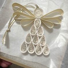 an ornament made out of white paper with a bow