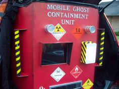 the back end of a red vehicle with signs on it