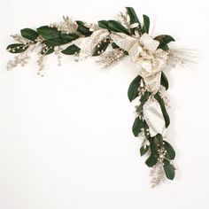 a white flower and green leaves decoration on a wall