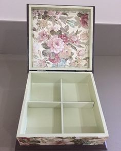 an open box with four compartments and flowers on it