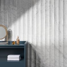 a bathroom with marble walls and blue vanity