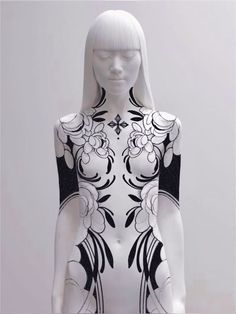 a white female mannequin with black and white designs on it's body