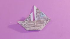 an origami boat made out of paper on a purple background with the word $ 10 printed on it