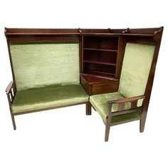 two chairs and a bookcase with green upholstered fabric on the back side