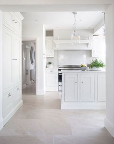 an empty kitchen with white cabinets and appliances