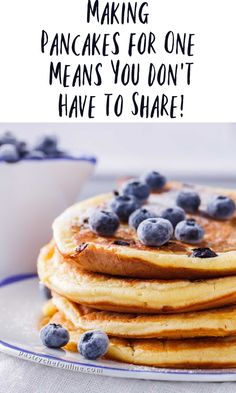 stack of pancakes with blueberries on top and the words making pancakes for one means you don't have to share