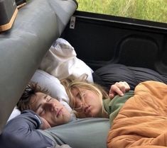 two people sleeping in the back of a truck