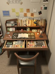 a desk with many books and papers on it in an office space next to a chair