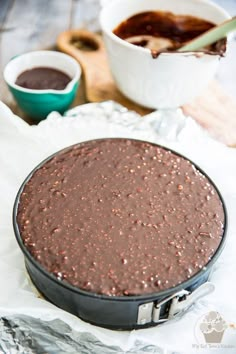 a chocolate cake sitting on top of a pan covered in frosting and sprinkles