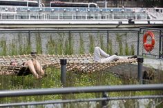 two people laying on hammocks in the water