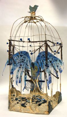 a bird cage with two blue birds in it