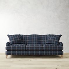 a couch sitting on top of a hard wood floor next to a white wall in an empty room