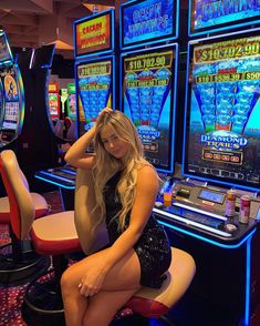 a woman is sitting in front of slot machines